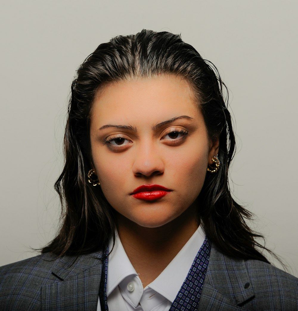 a woman in a suit and tie with red lipstick