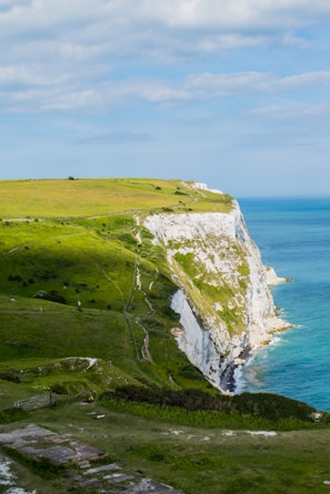A vibrant group photo at Durdle Door with bright blue skies and rugged cliffs.