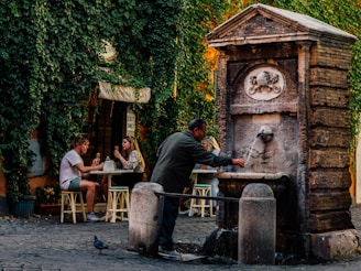 a group of people sitting at a table next to a fountain