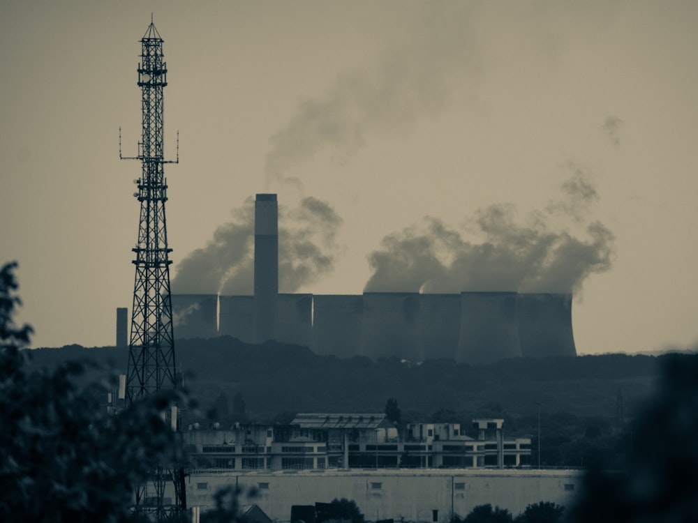 smoke billows from the stacks of industrial buildings