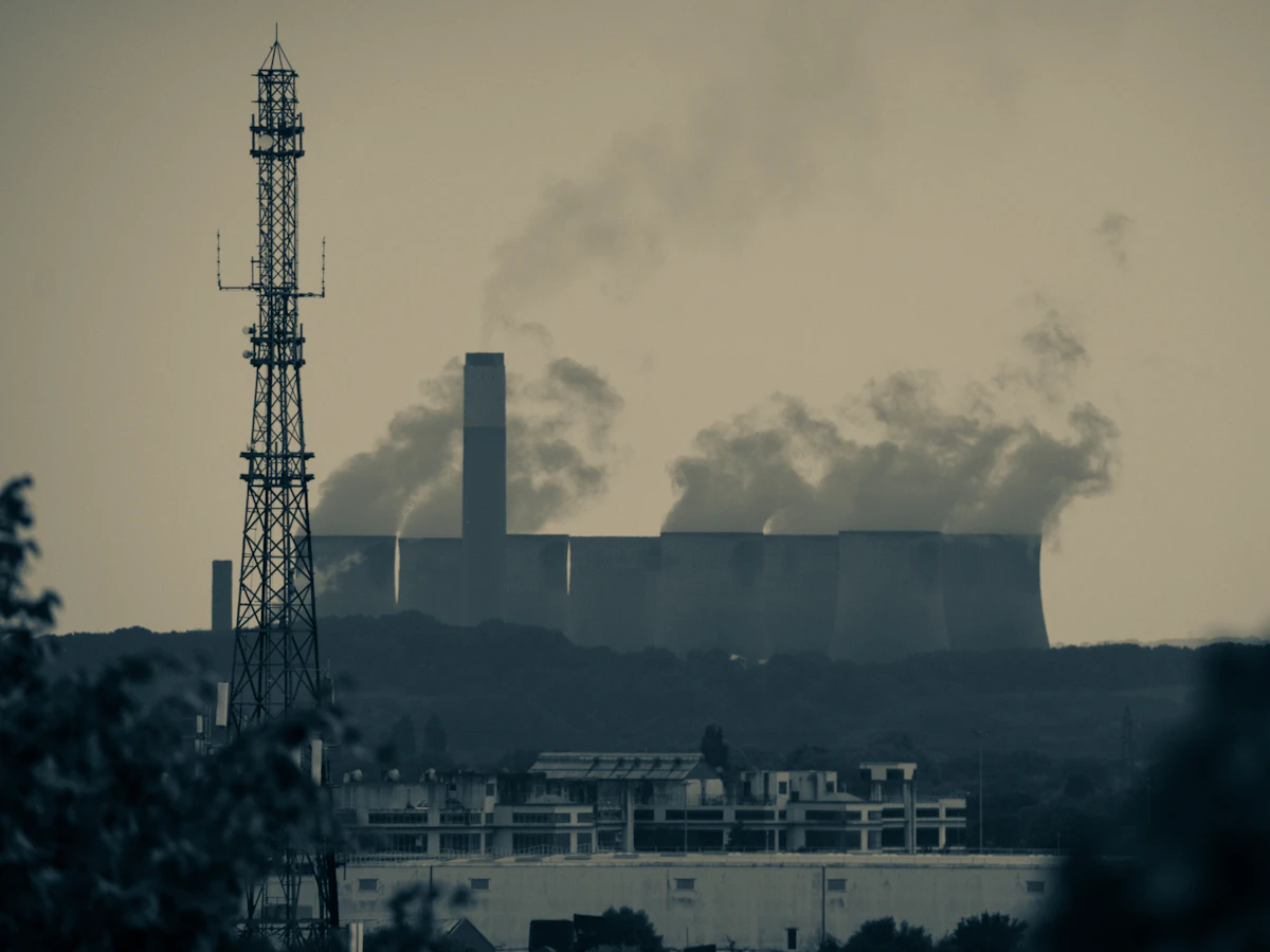 Coal-fired power station with cooling towers and a transmission pylon at dusk, the generation mix behind India's published grid emission factor