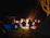 A group of peer support specialists gathered around a campfire, sharing stories and learning together.