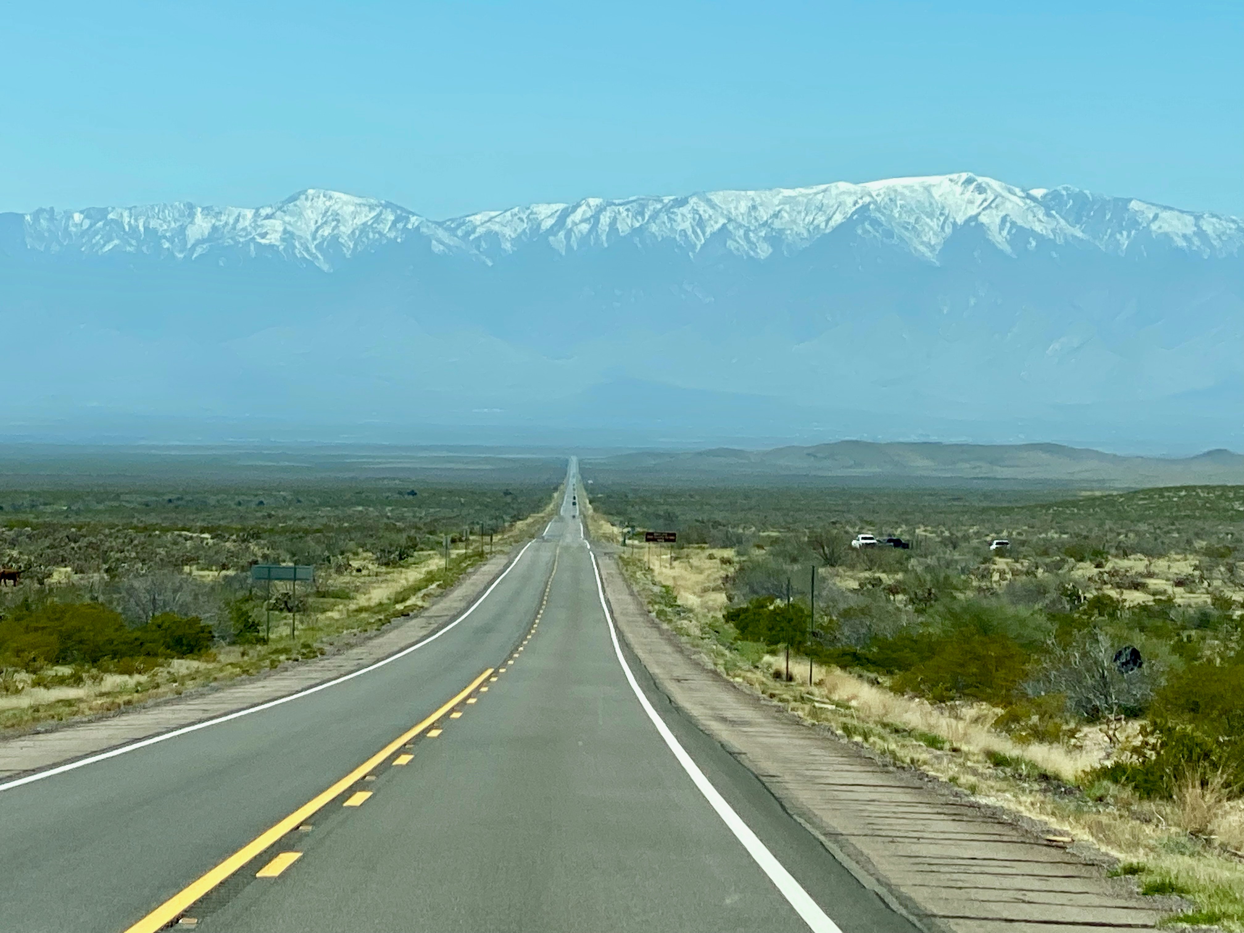 Una carretera con una cadena montañosa al fondo
