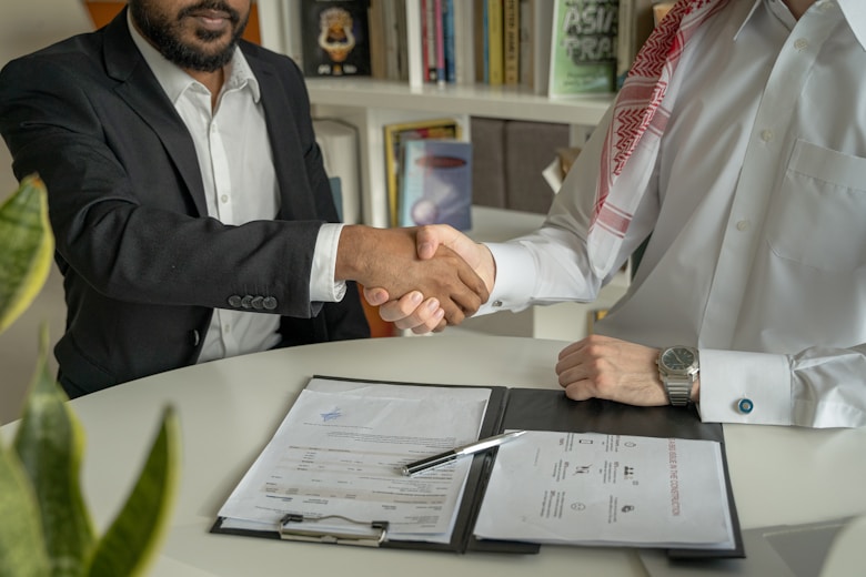 a couple of men shaking hands over a desk