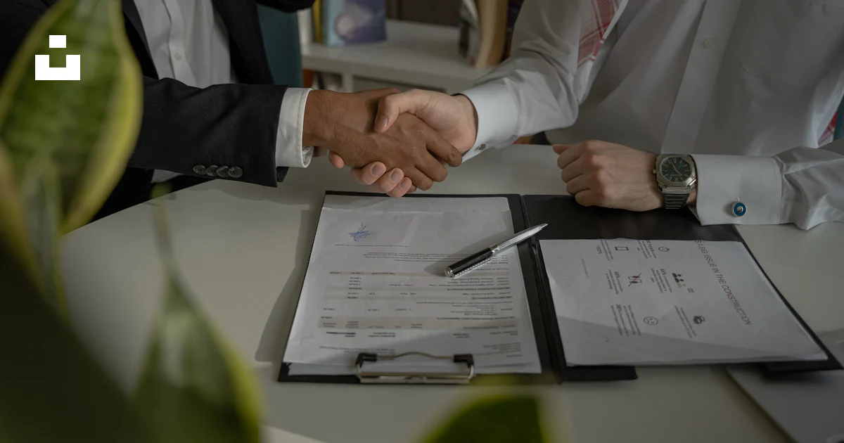 Duas pessoas apertando as mãos sobre um pedaço de papel foto – Imagem ...