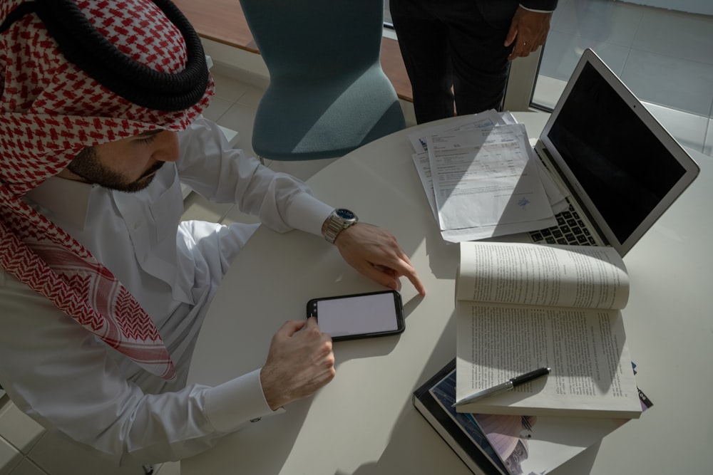 a man sitting at a table looking at a tablet