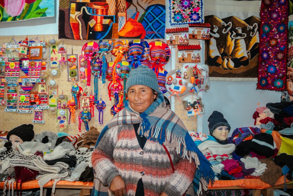 a woman standing in front of a wall covered in jewelry