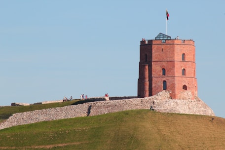 a tall brick tower sitting on top of a lush green hillside