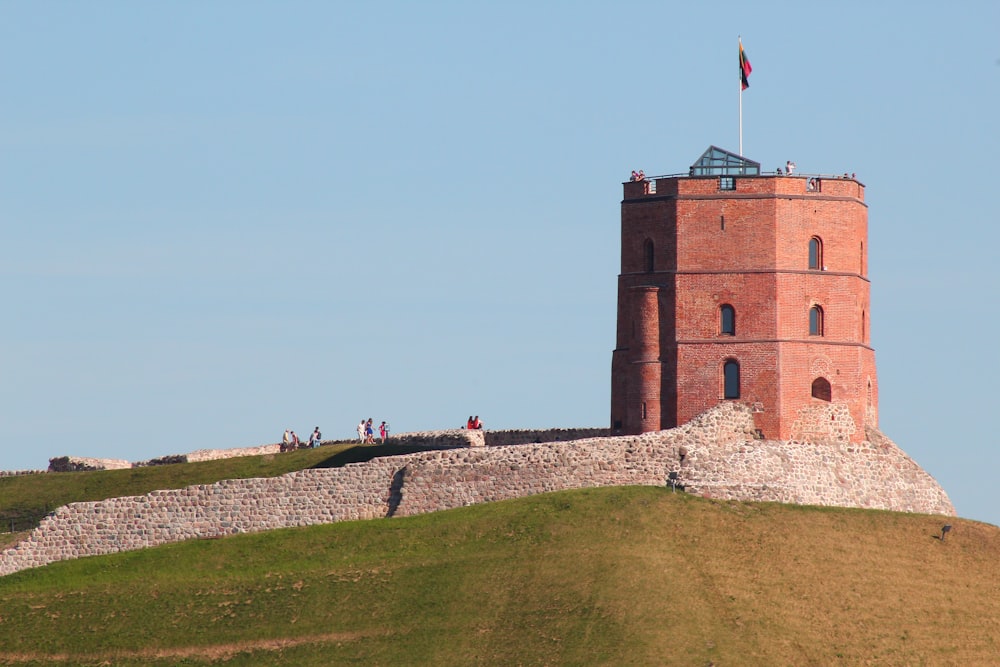 a tall brick tower sitting on top of a lush green hillside