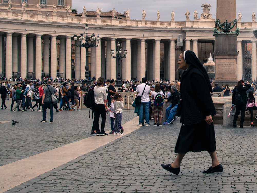 a crowd of people standing around a fountain