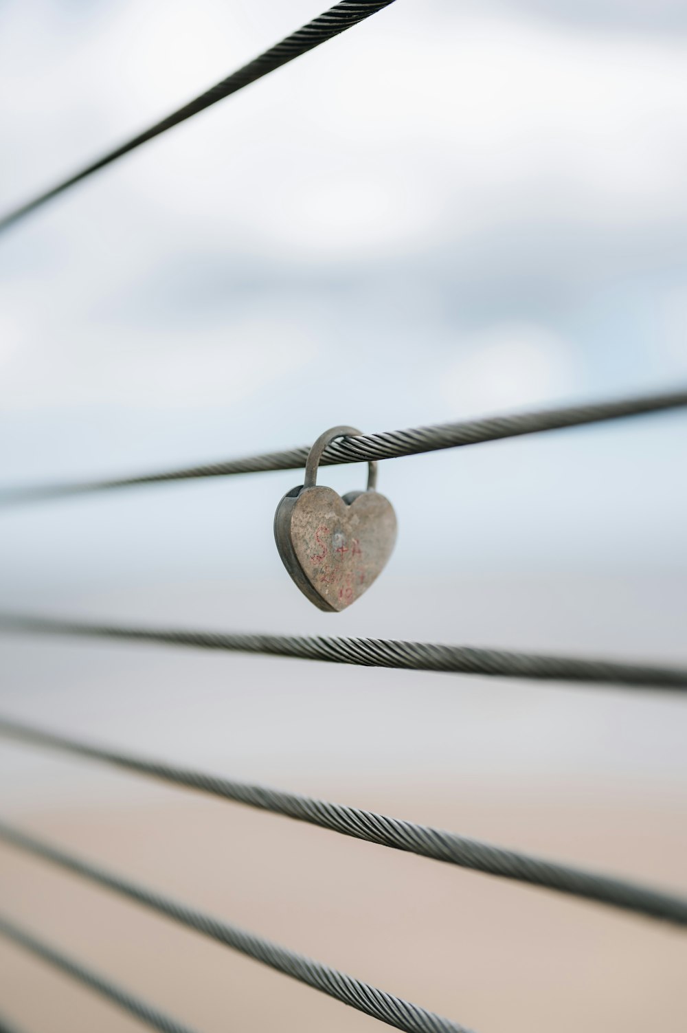 a heart shaped padlock attached to a wire
