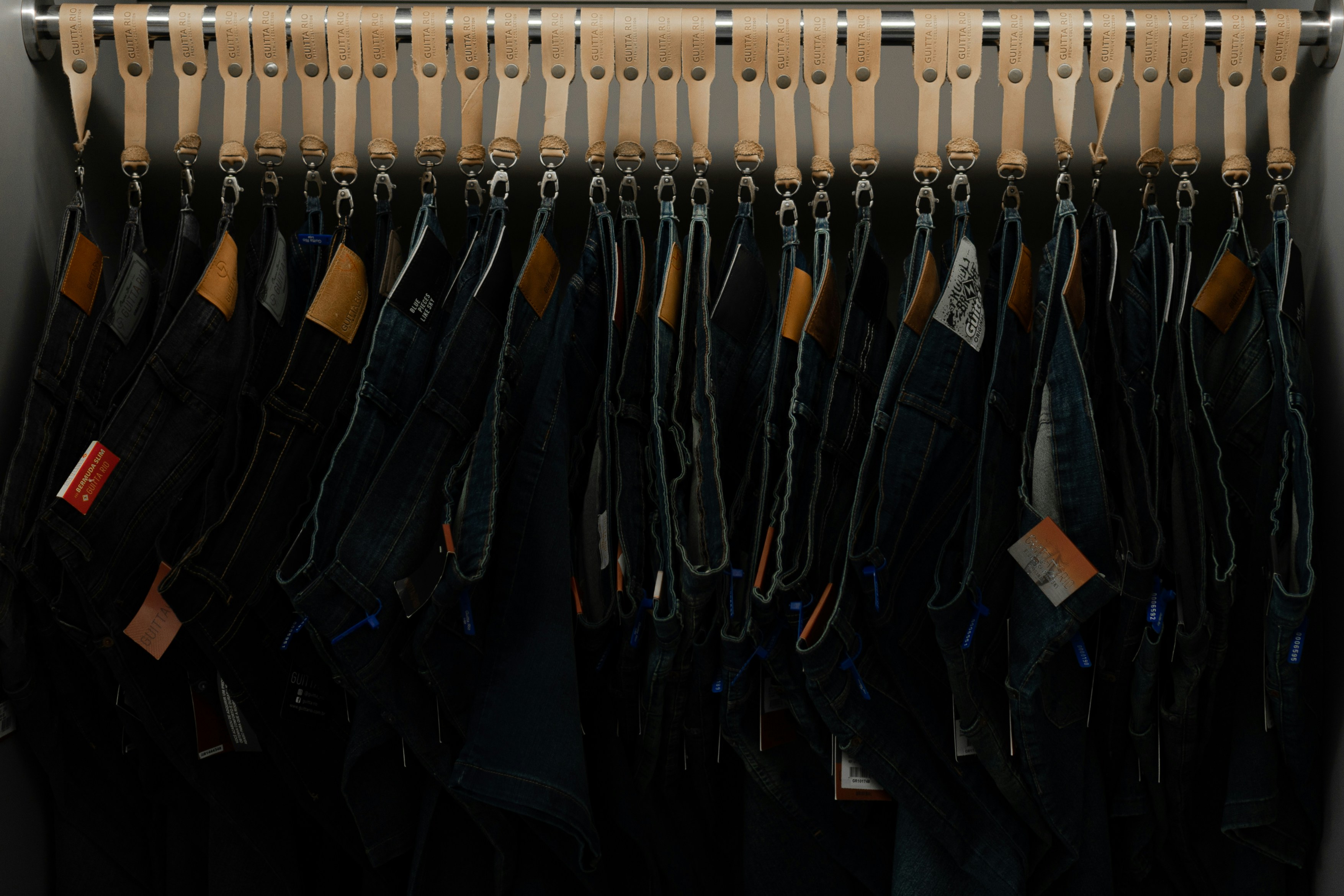 a bunch of jeans hanging on a rack