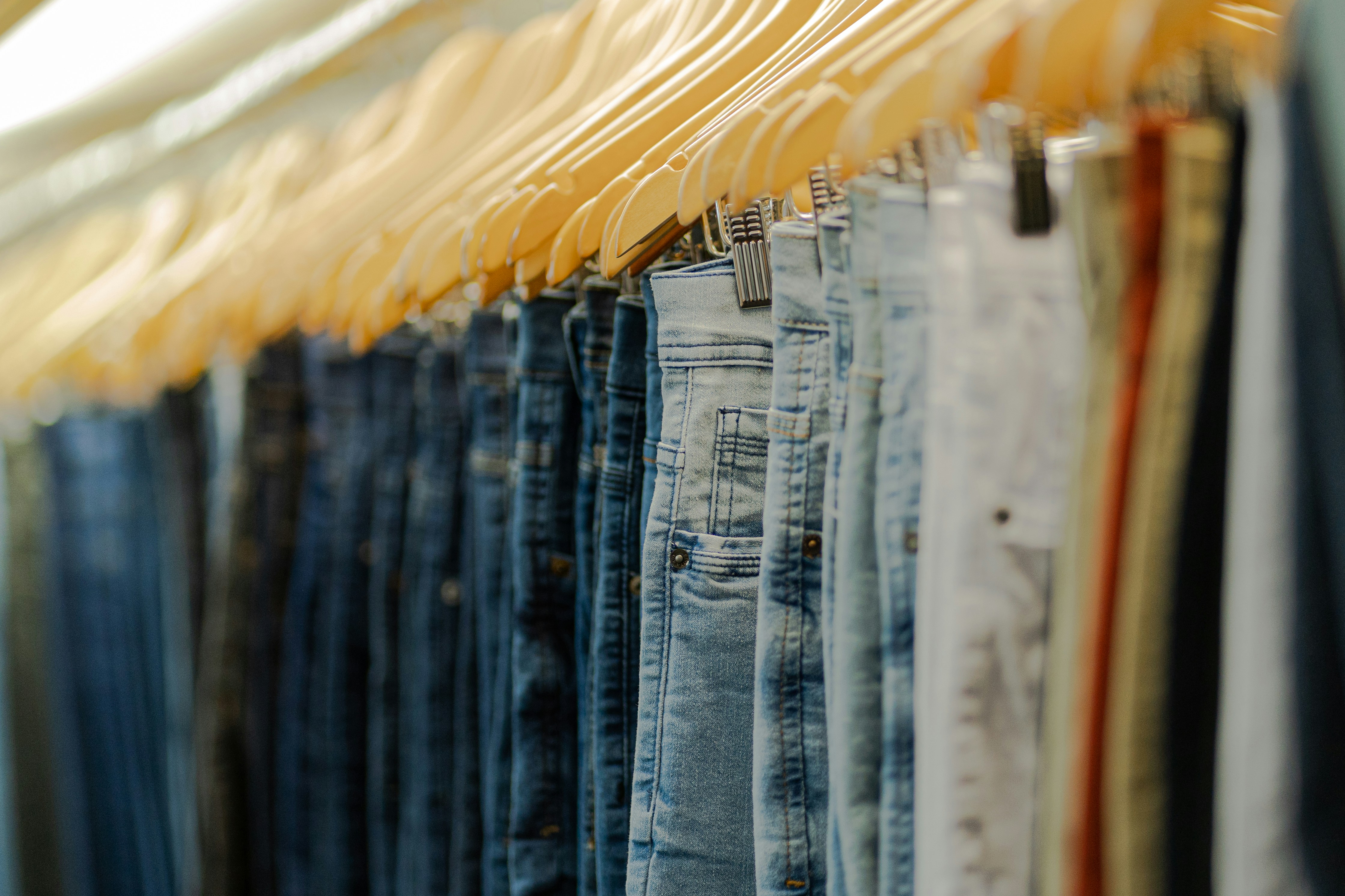 How to Care for Your Clothes So They Last Longer and Look Better – a row of jeans hanging on a rack