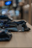 Folded denim jeans and a casual t-shirt laid out on a wooden table.