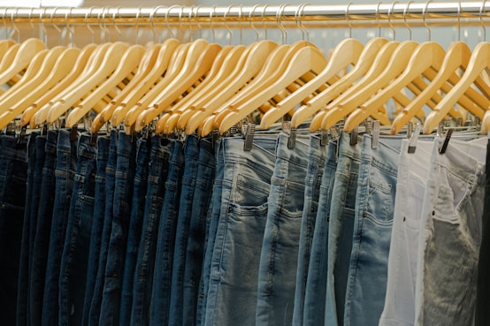 a row of jeans hanging on a rack