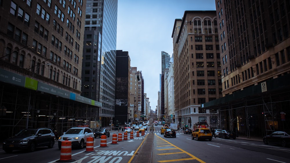 a city street lined with tall buildings and traffic cones