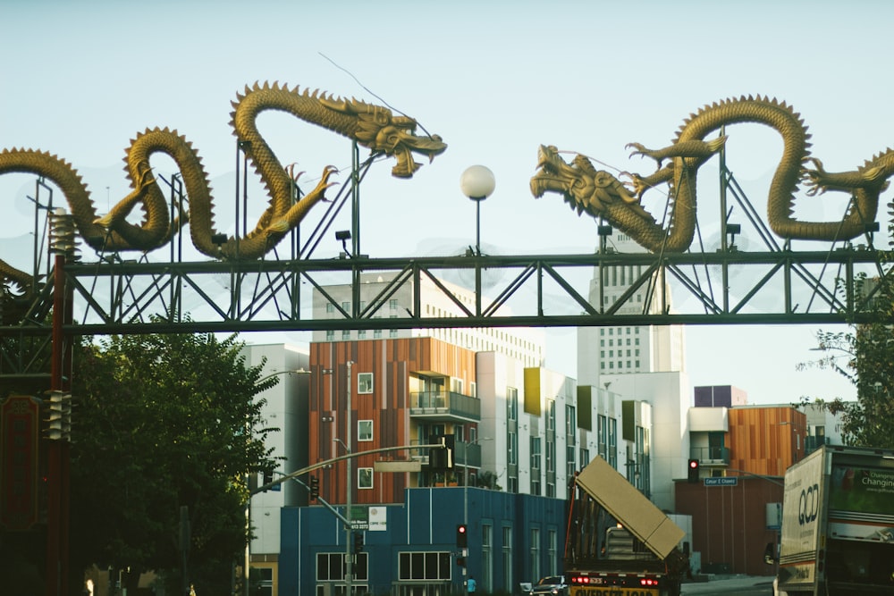 Une grande sculpture de dragon au sommet d’un pont au-dessus d’une rue