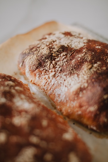 A close-up of a freshly baked, golden-brown loaf of bread with a crisp crust.