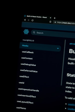 A dark-themed computer screen displaying the React Hooks documentation page. The left side lists various hooks like useCallback, useContext, and useEffect. The top shows the browser tab with the title 'Built-in React Hooks - React' and the URL highlighting a secure HTTPS connection.