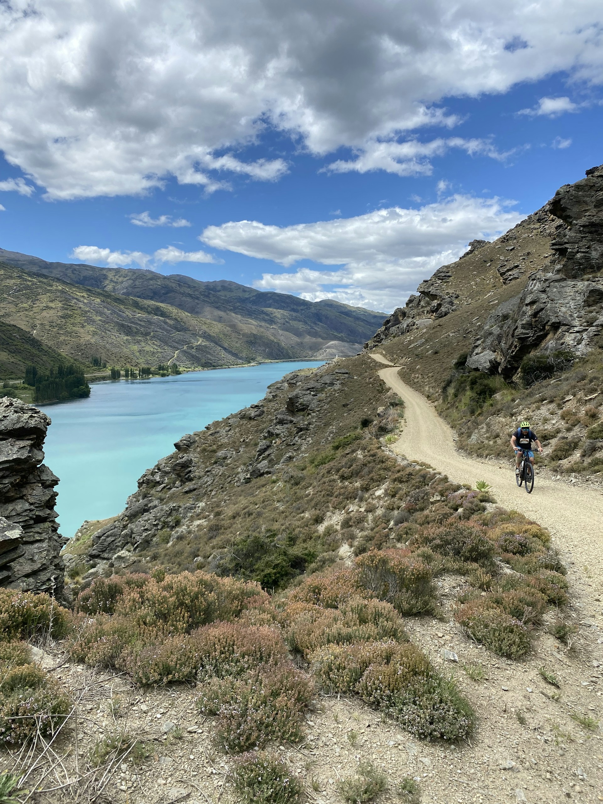 A cyclist riding through a scenic mountain trail, embodying the spirit of adventure and fitness.