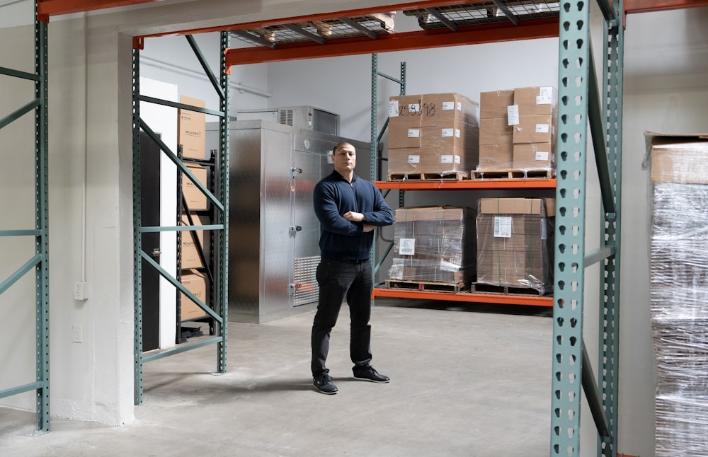 a man standing in a warehouse next to boxes