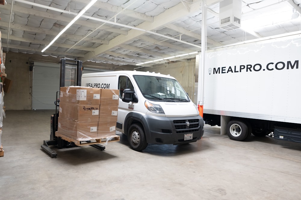 a white delivery truck parked in a warehouse