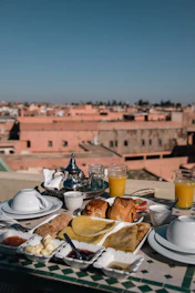 a table topped with plates of food next to a cup of orange juice