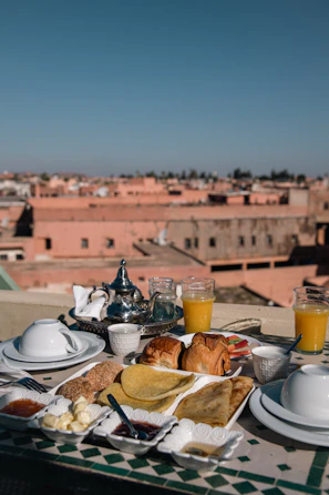 a table topped with plates of food next to a cup of orange juice