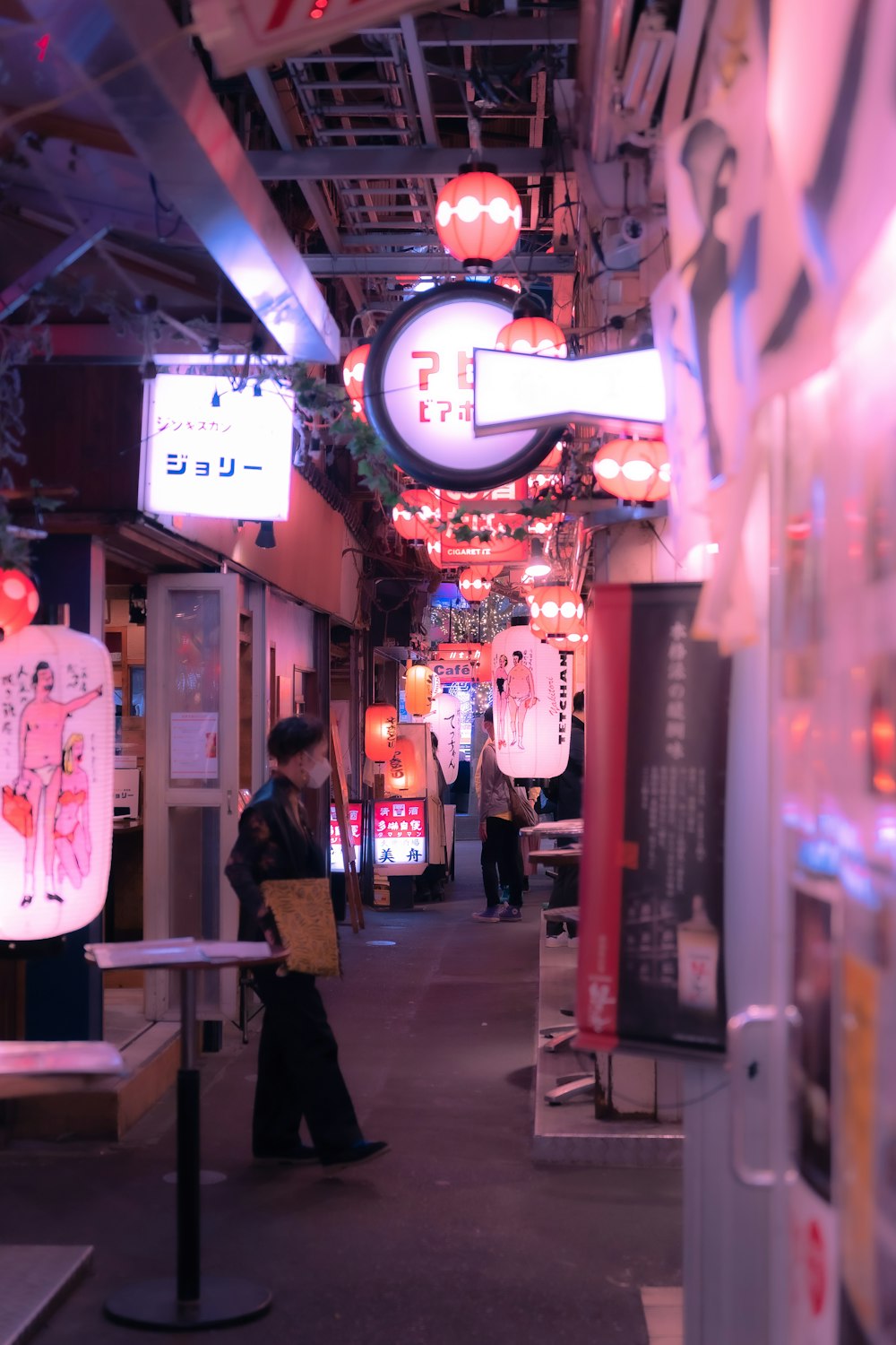a woman walking down a street next to neon signs