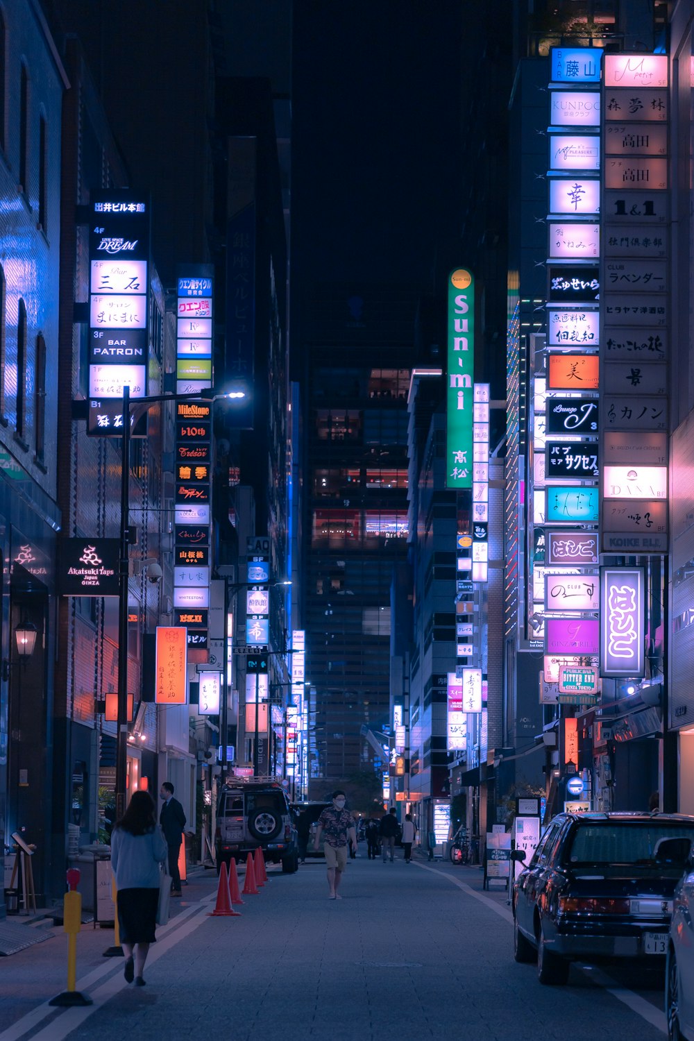 a woman walking down a city street at night