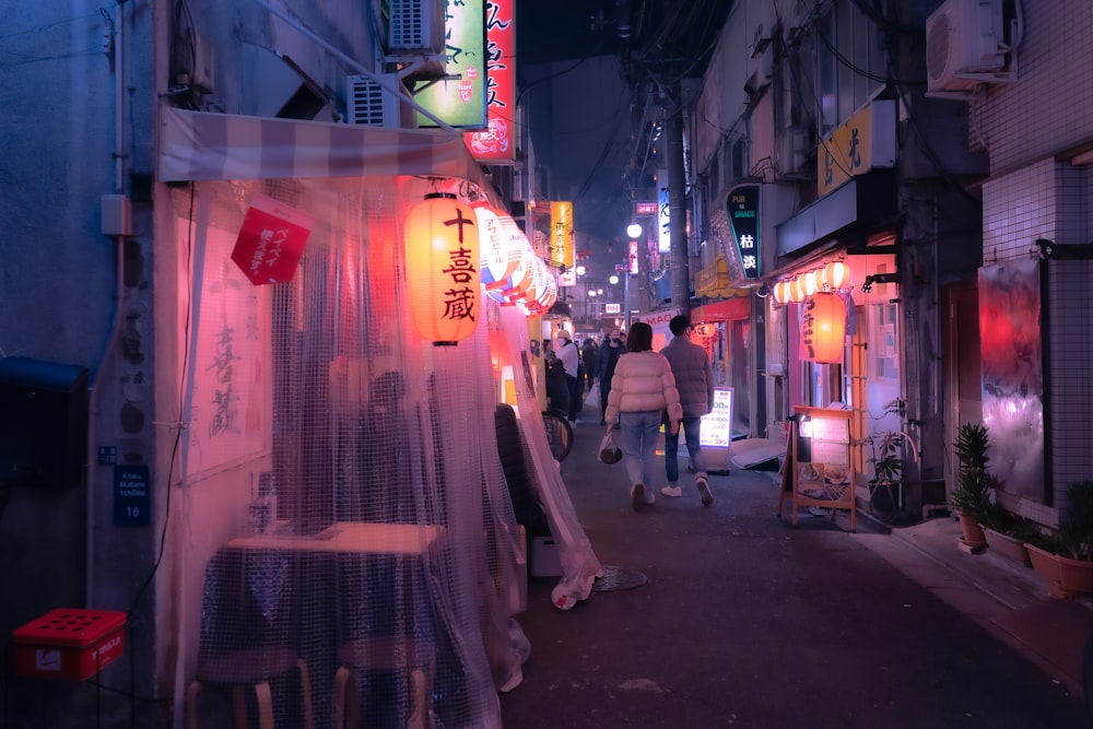 a group of people walking down a street at night