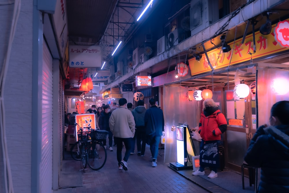 a group of people walking down a street at night