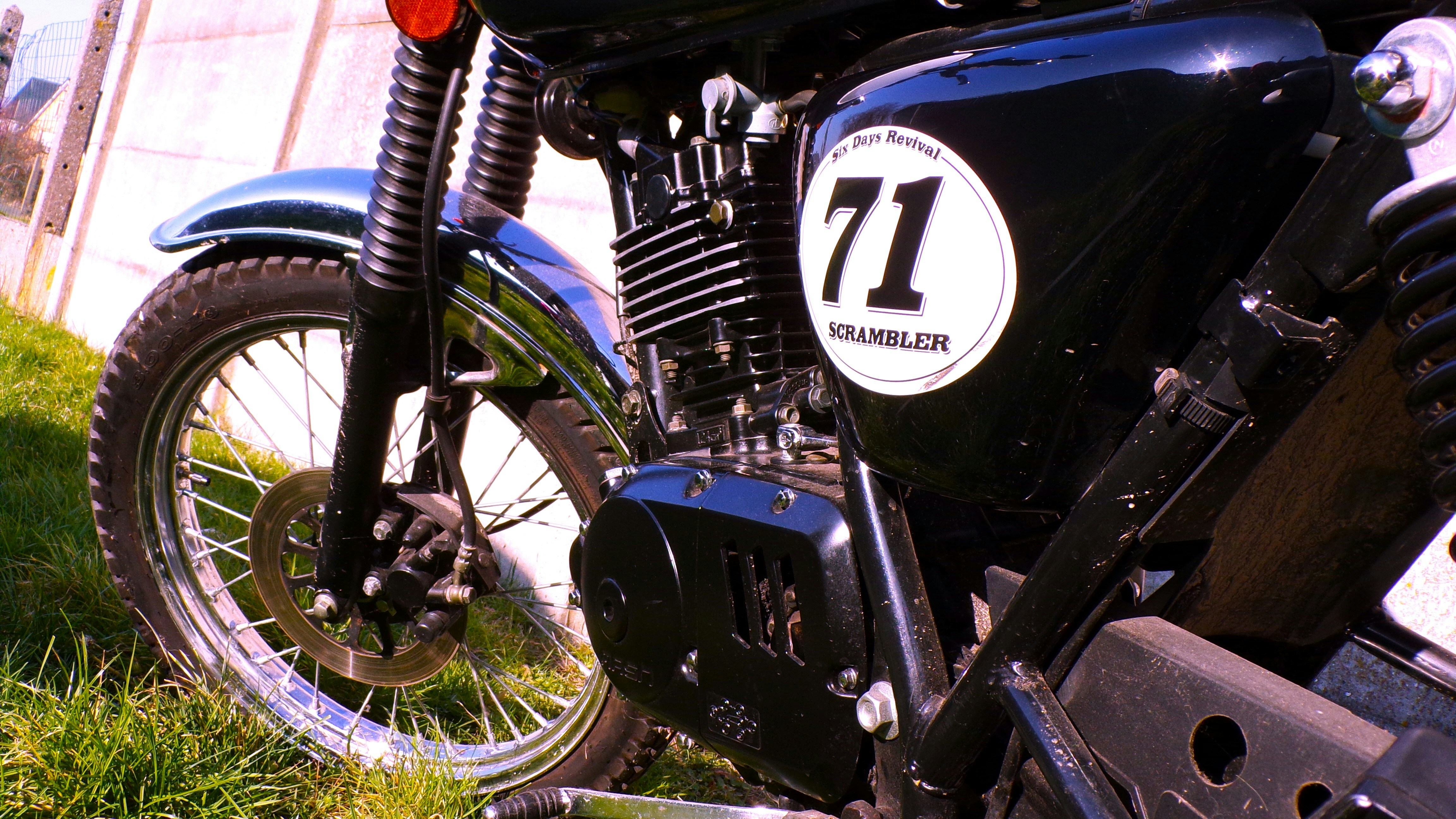 a close up of a motorcycle parked in the grass