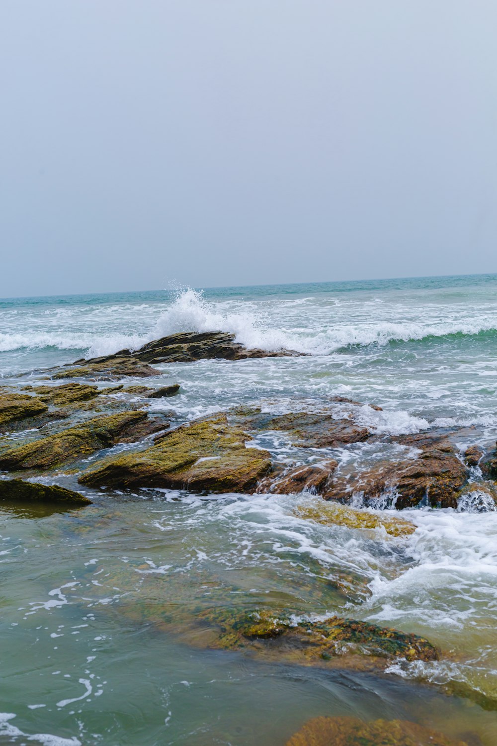 a person standing on some rocks in the water