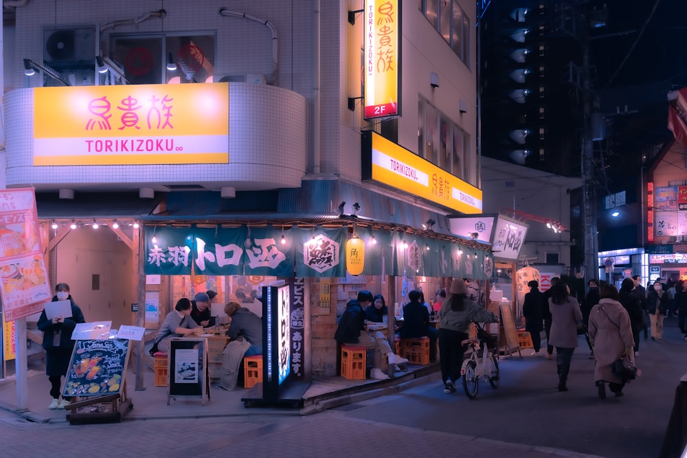 a group of people walking down a street at night