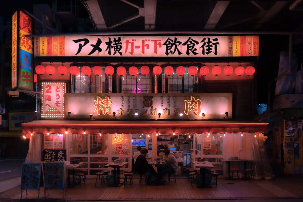 two people sitting at a table in front of a restaurant