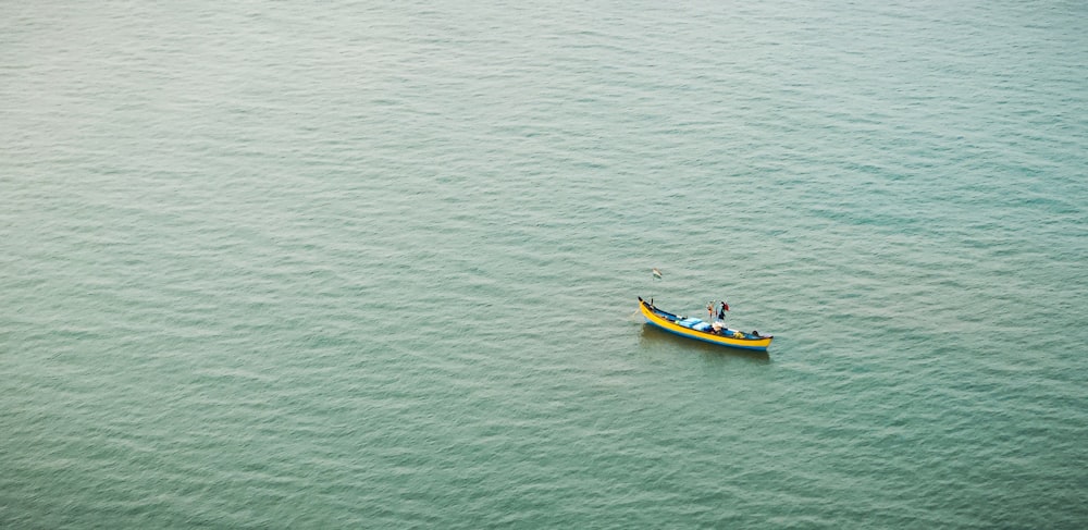 Un pequeño bote amarillo flotando sobre un gran cuerpo de agua