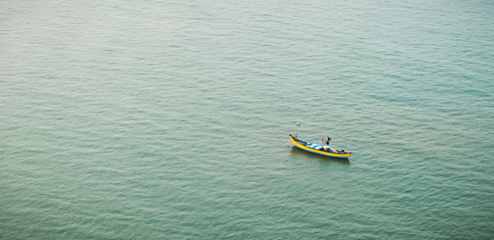 a small yellow boat floating on top of a large body of water