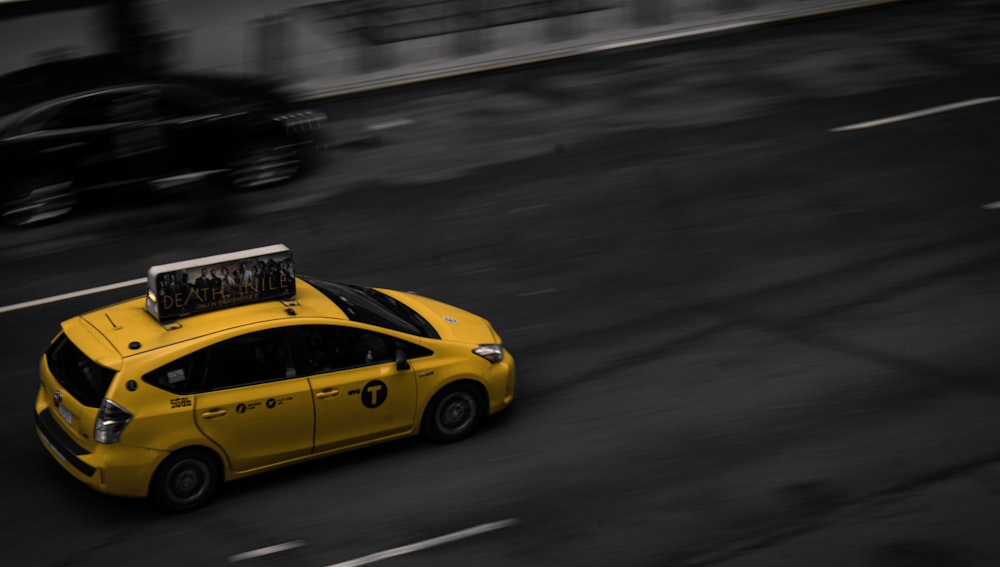 a yellow taxi cab driving down a street
