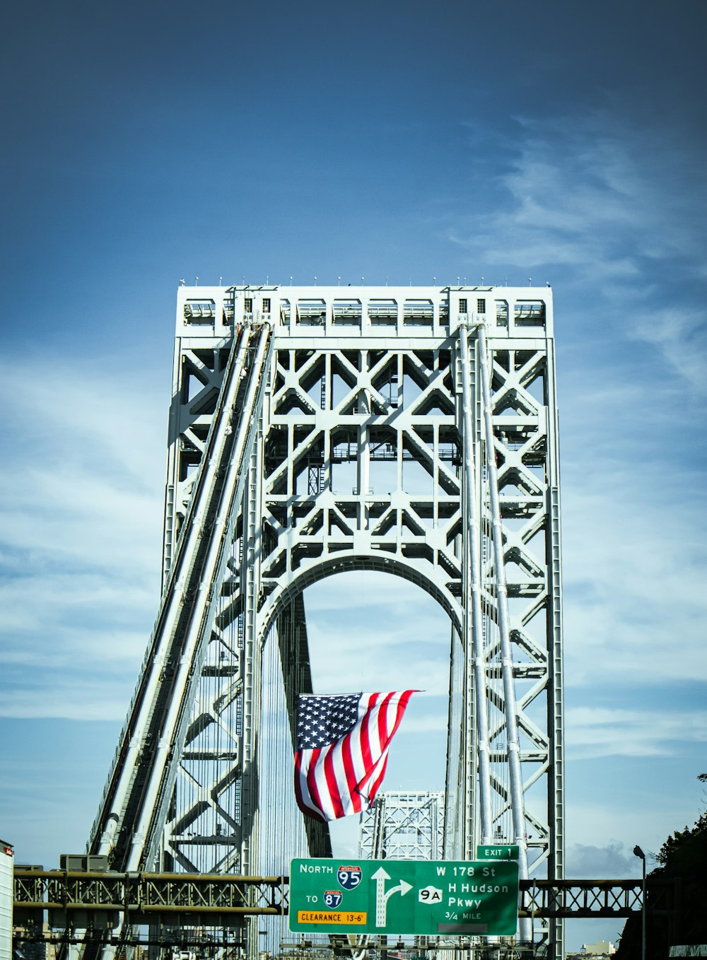 an american flag flying on the side of a bridge