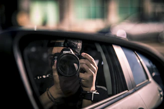 a person taking a picture of themselves in a car mirror
