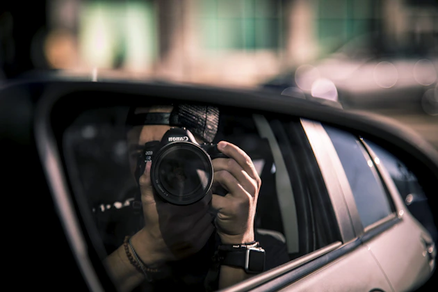 a person taking a picture of themselves in a car mirror