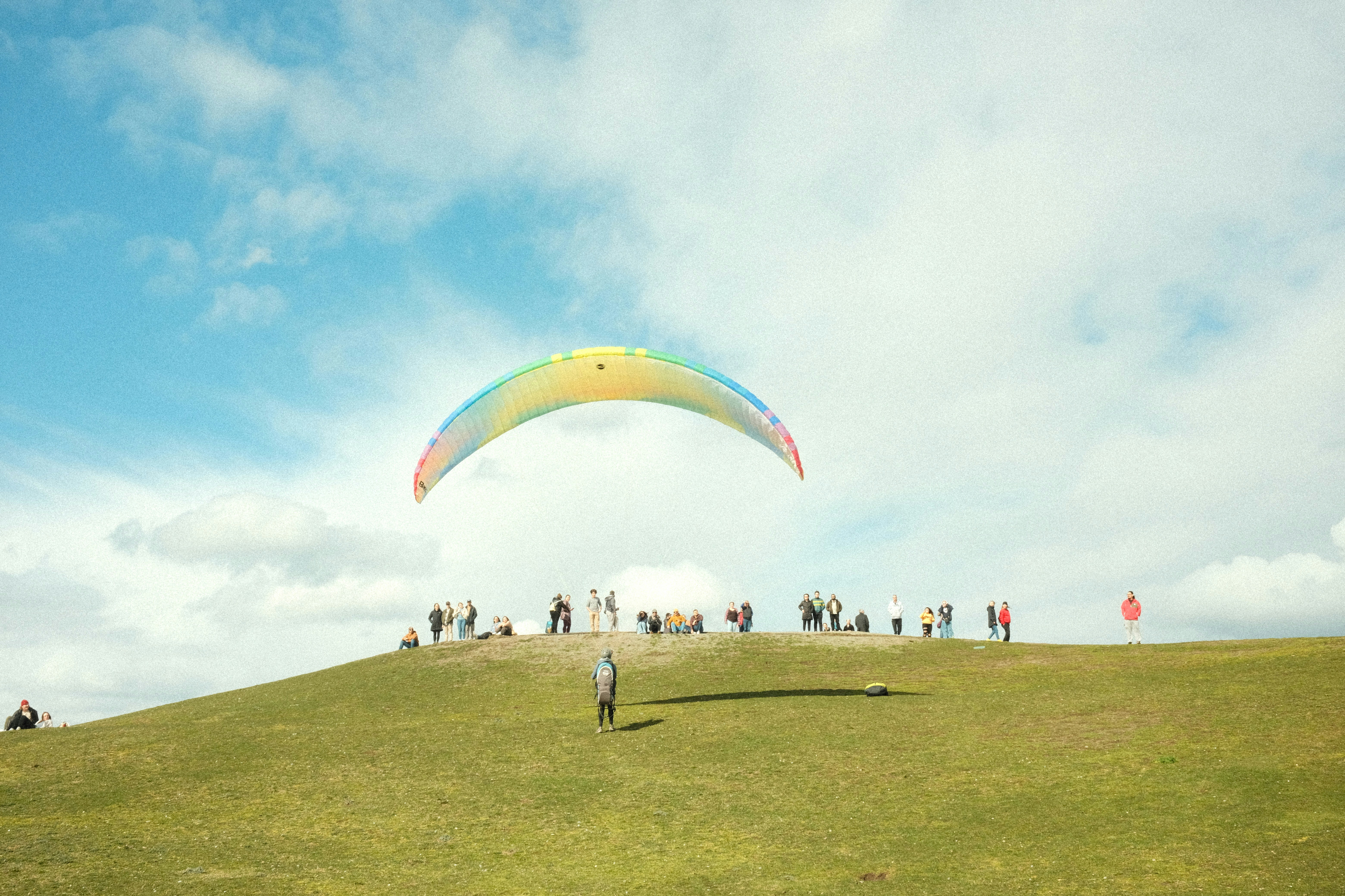 a group of people standing on top of a lush green hillside