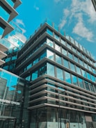 Sleek office building with glass facade reflecting the sky.