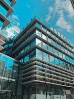 Modern commercial office building with glass facade reflecting the blue sky.