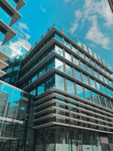 Modern office building with blue glass facade reflecting the sky