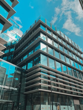 Modern office building with blue glass facade reflecting the sky