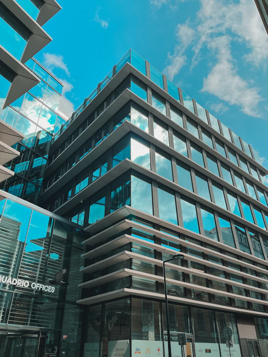 A sleek office building with modern glass architecture reflecting the sky.