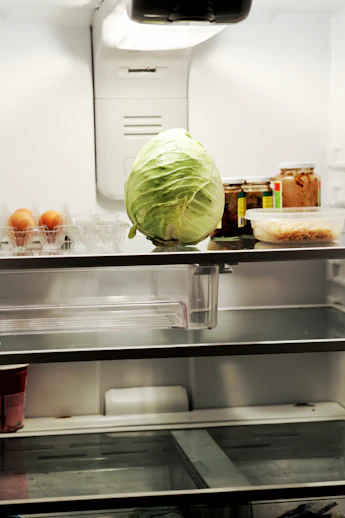 a head of cabbage sitting on top of a refrigerator