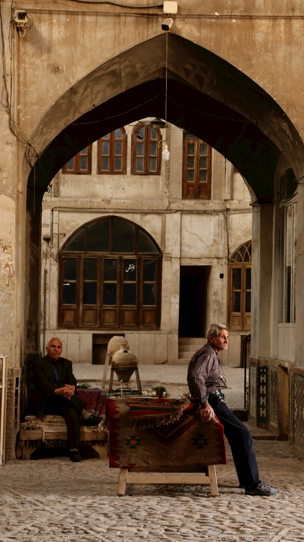 a man sitting on a bench in front of a building